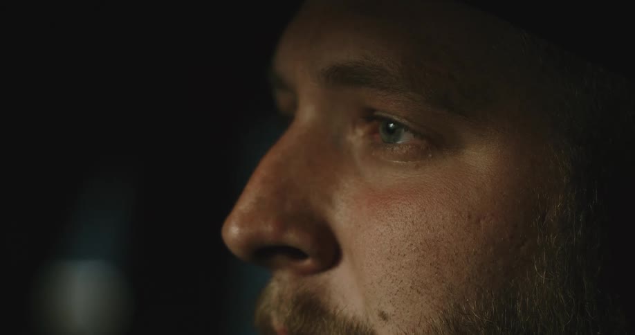Close up view of a mans upper face and he is moving his eyes around