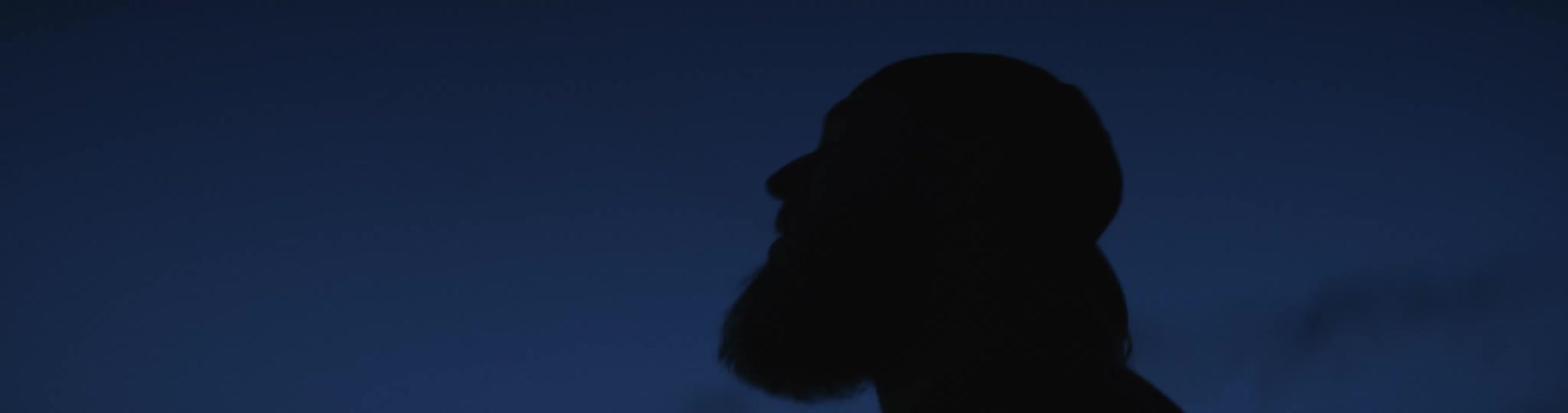 A man smoking outside at night