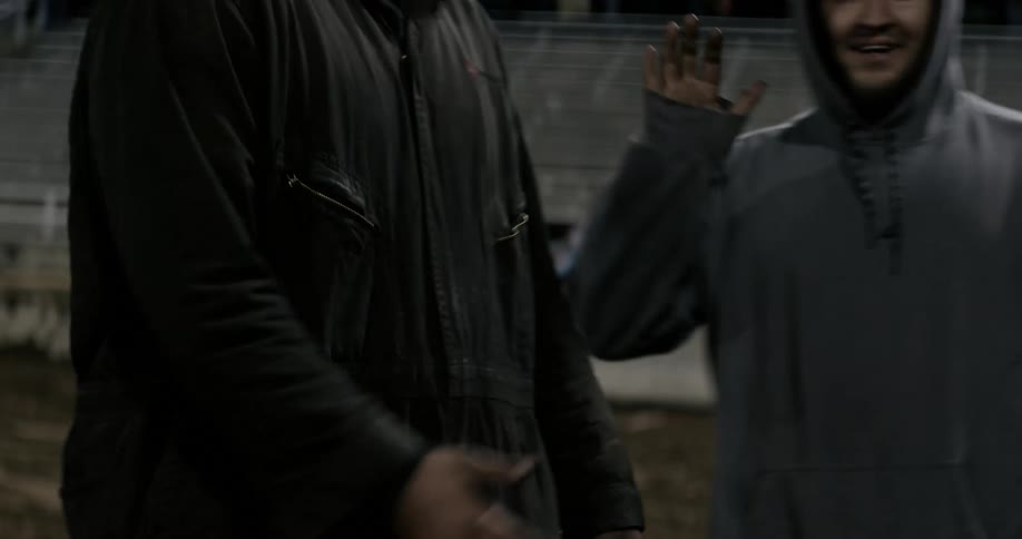 Men are standing around shaking hands and laughing in an arena