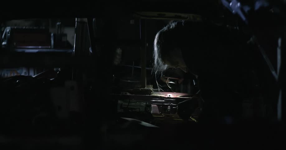 A female girl is standing in front of a vehicle in the night time