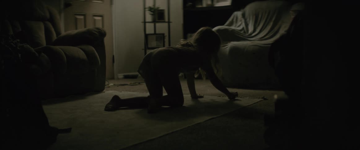 A child is sitting on the floor playing with her toys inside