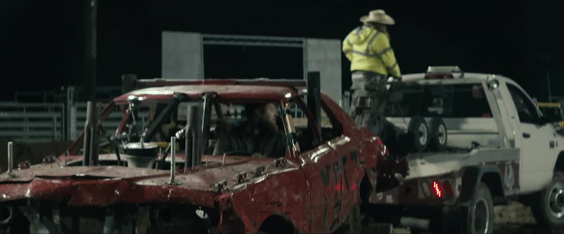 A few driving a vehicle in the dirt at night time
