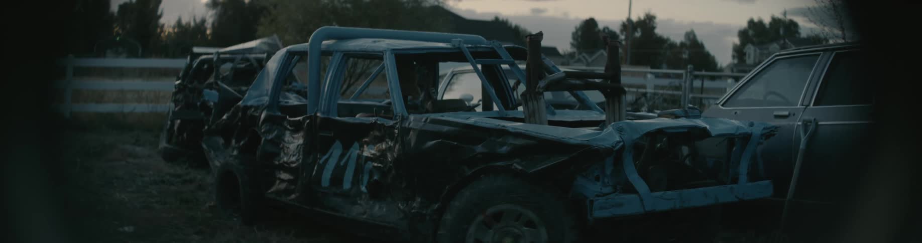 A wrecked car is in the parking lot