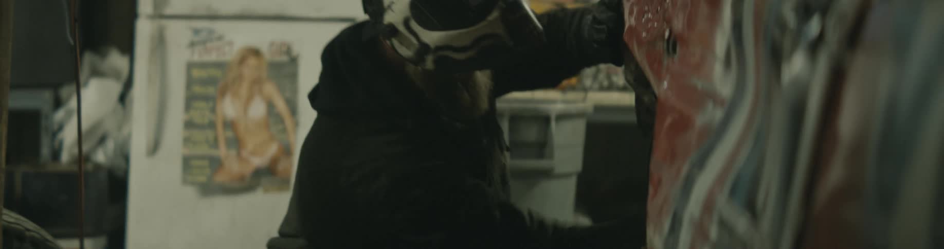 A person hammers dents out of their demolition derby car