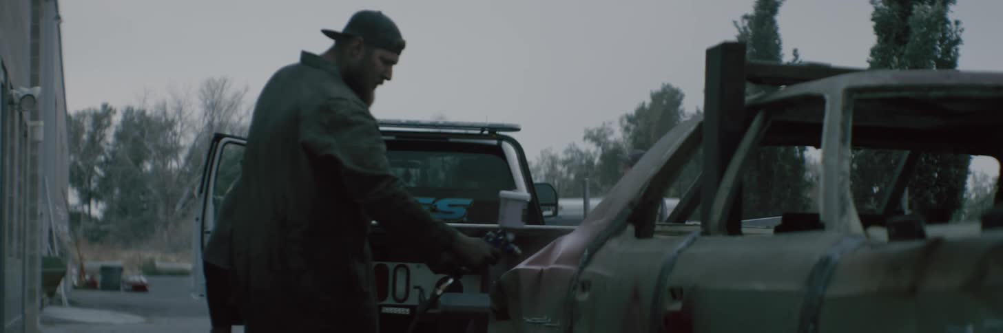 A man is cleaning his car outdoors