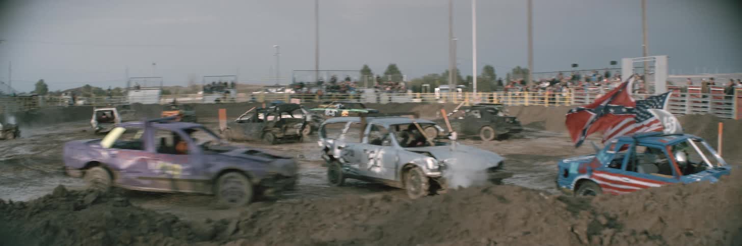 Cars bumping into each other in the dirt road outside