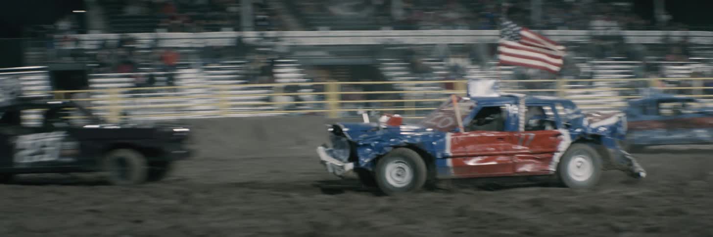 People are driving cars at a racing show at night