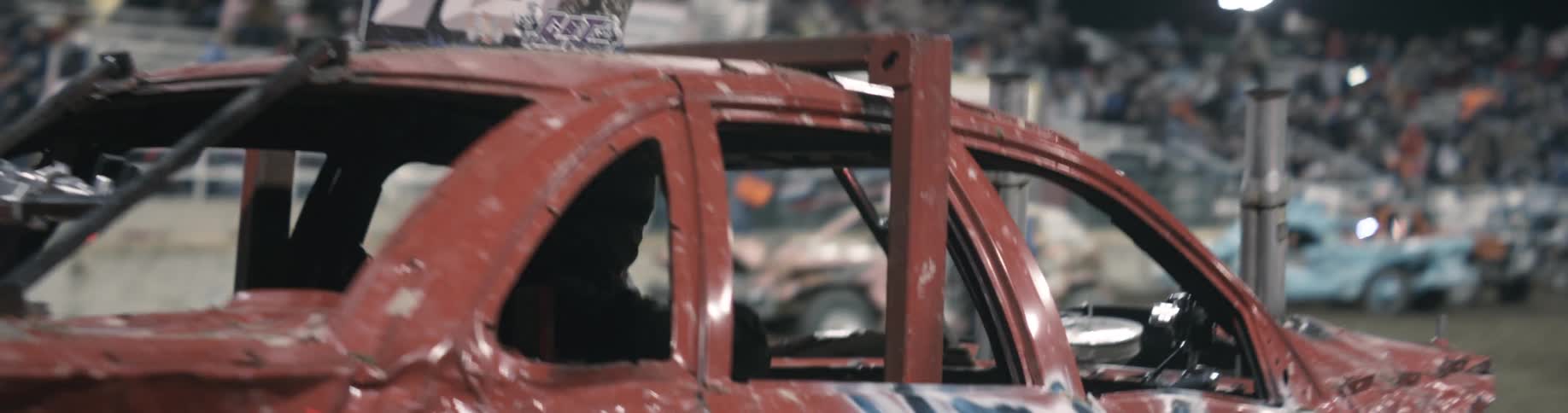 A person is driving a race car in a stadium