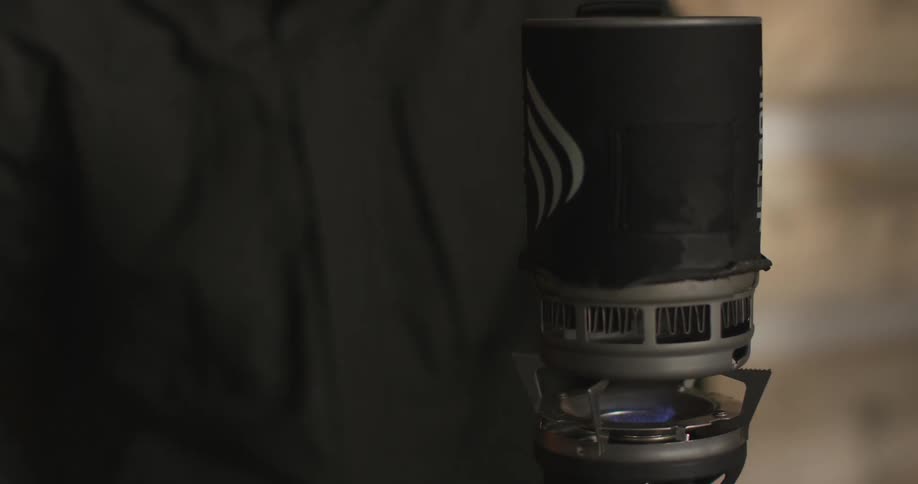 A man uses a camping torch to heat something up