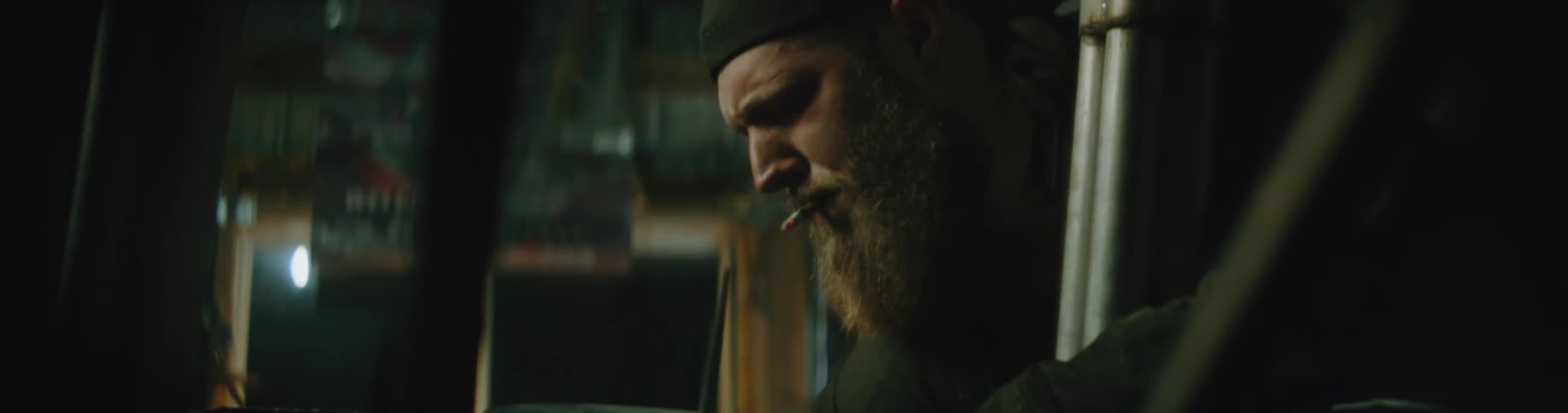A mechanic smokes while working on the engine