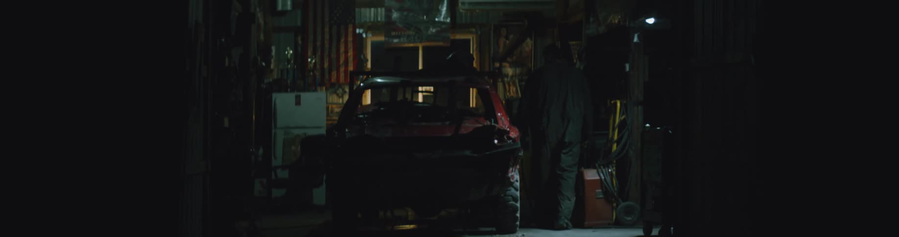 A man is walking around a garage at night