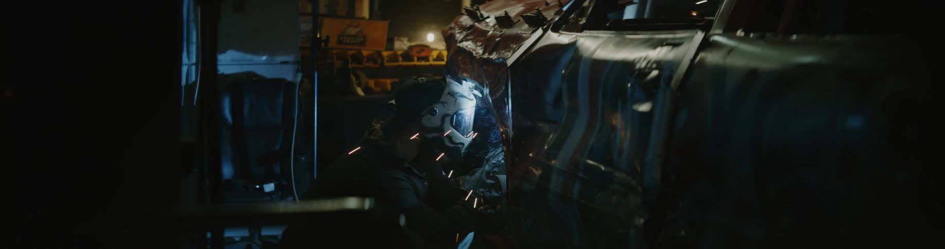 Sparks fly as a person welds on their car