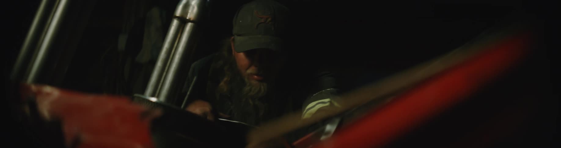 A man is sitting in his car that is parked outside