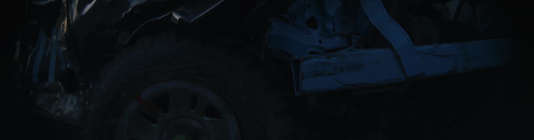 The wreckage of a car outdoors in the evening