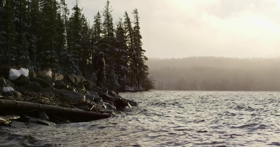 The water is rough on this coastline as a man stands on the rocks