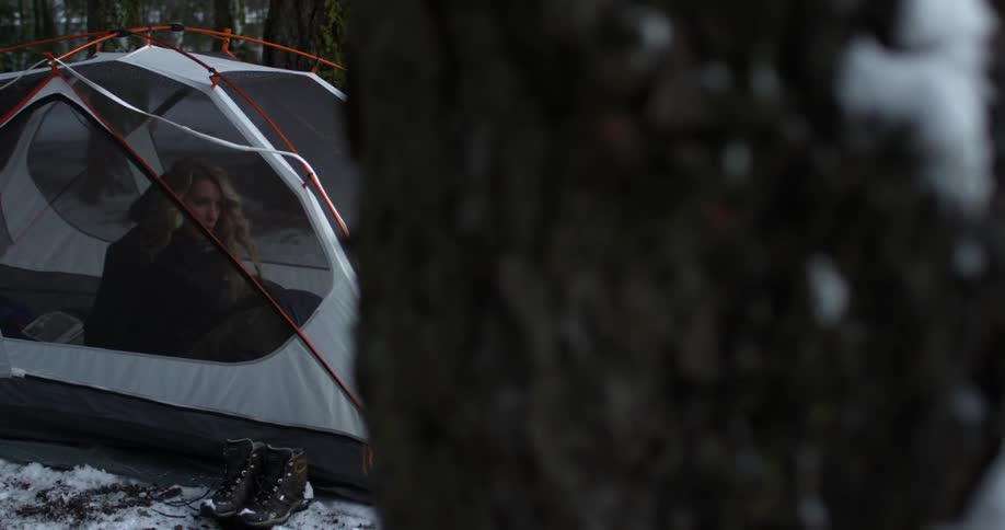 A woman is sitting in a tent