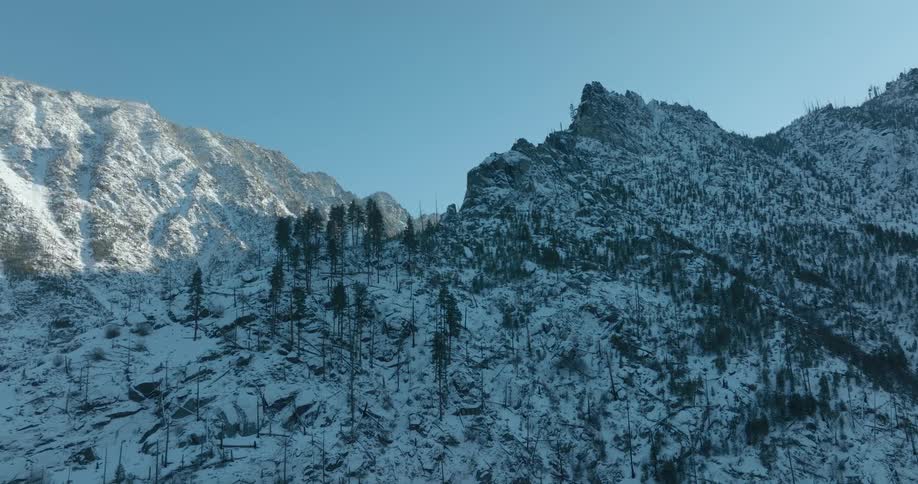 Subtle traverse just below the jagged ridge of a snow dusted mountain slope