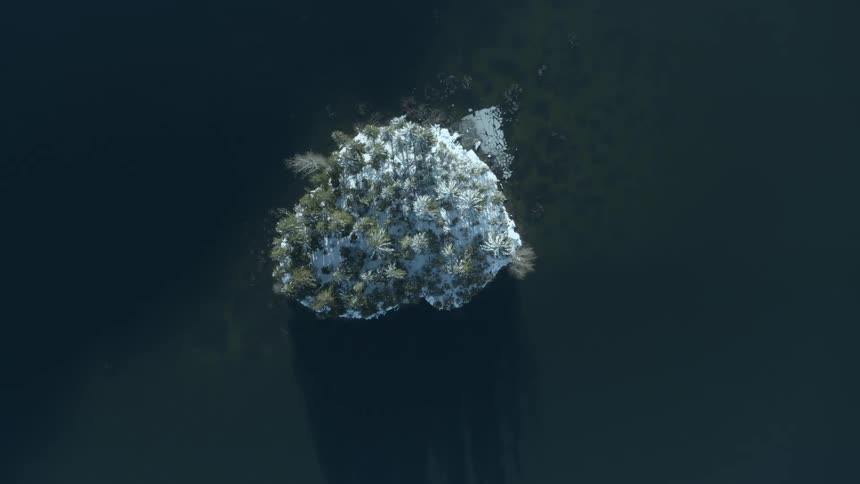 Ascending twist above a beautiful little island in the middle of a deep mountain lake