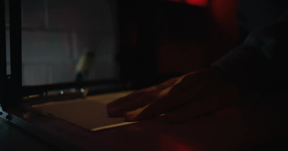 A person working on images in a dark room