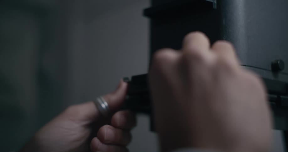 Male photographer inserts piece into enlarging machine