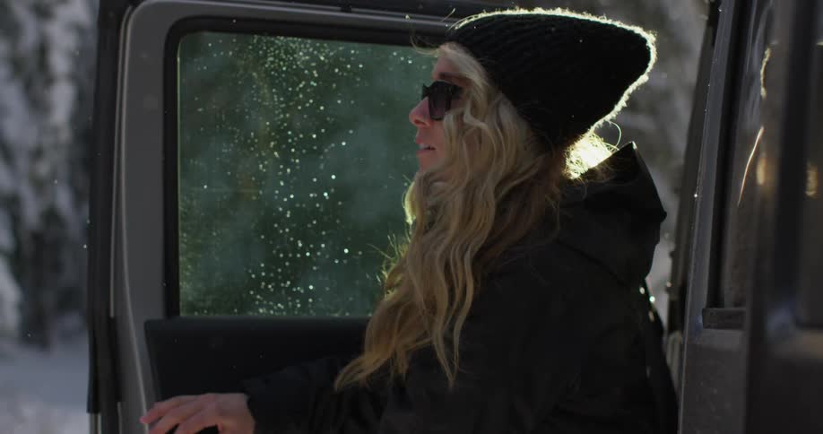 A woman opens a car door and exits
