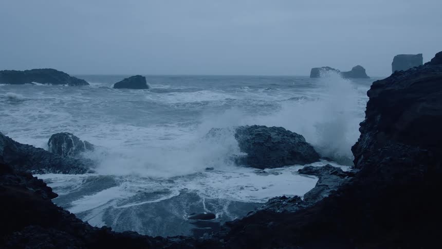 Ocean waves crashing in to a cliff on the shore