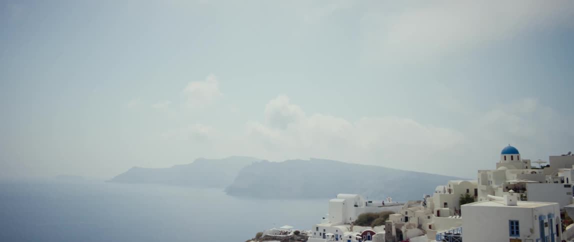 Fog covers water near town full of white clad buildings