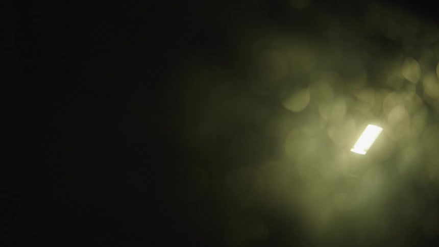 A single light is seen in the black