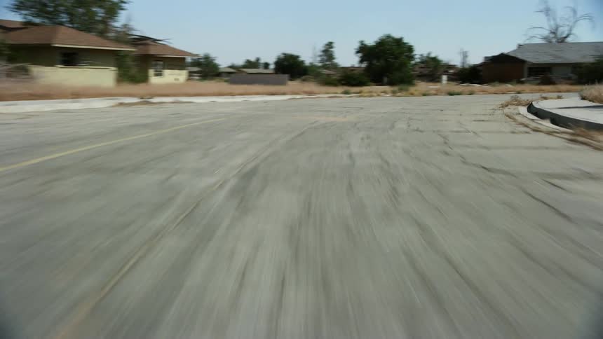 Car speeds around a bend on a torn up road