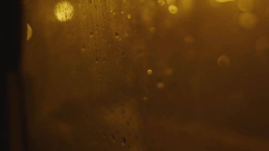 Rain falling on a car window as it drives
