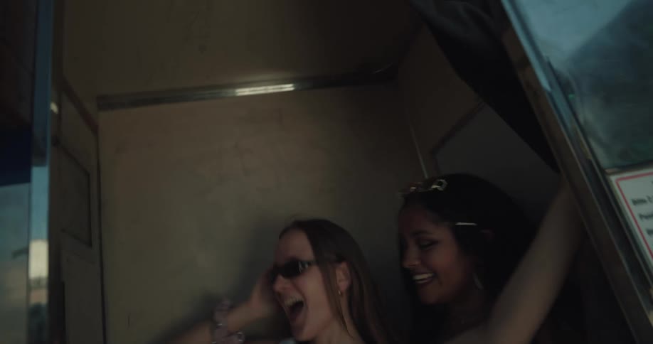 Two women running into a photo booth