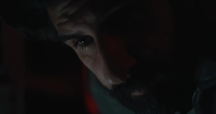 A creepy man looks around in the pitch black night