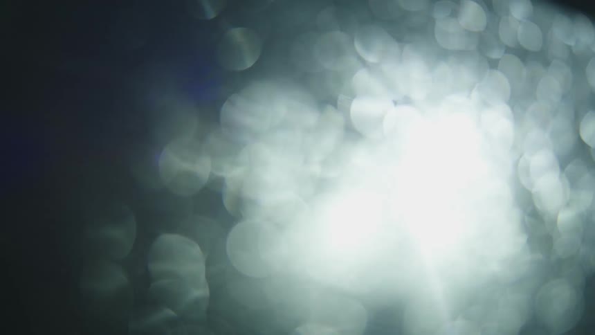 Lights pass by shining on glass in circles
