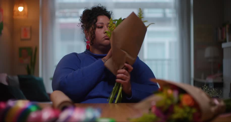 A woman gathers flowers into a bouquet