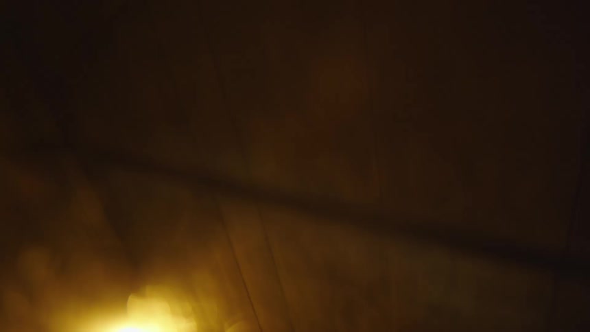 Yellow light and wires on a ceiling at night