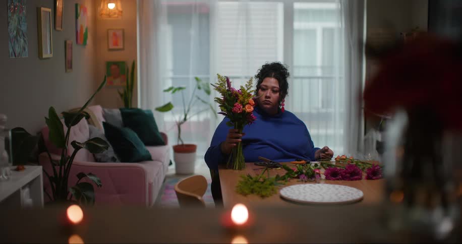 A woman gathers flowers into a bouquet