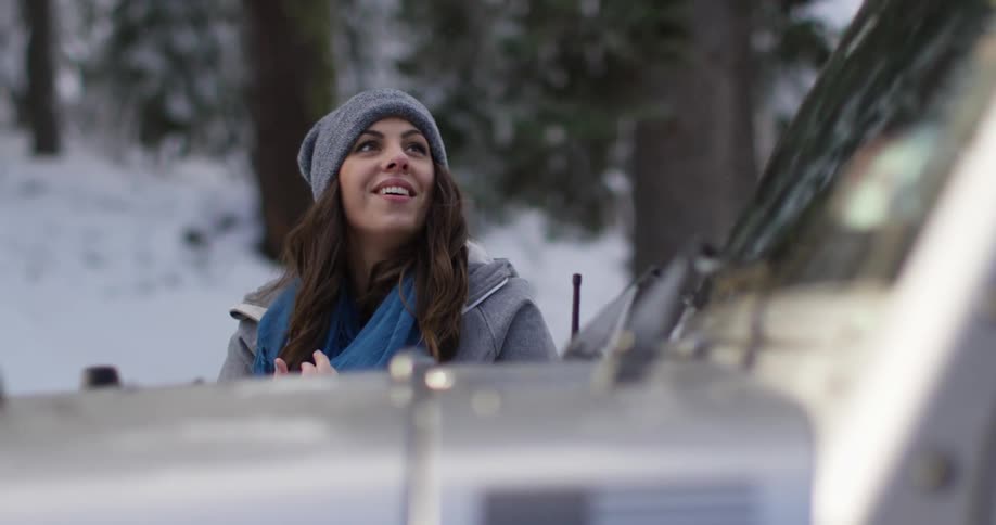 A woman walks by a vehicle looking up