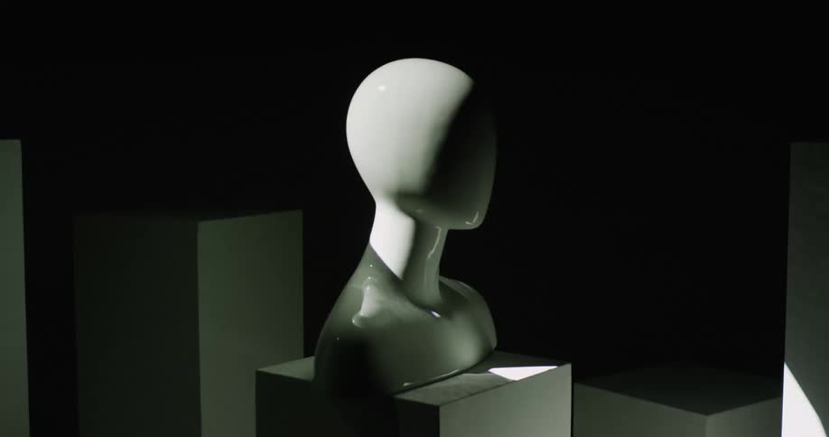 Lights flash in a room with a statue of a head sitting on a block