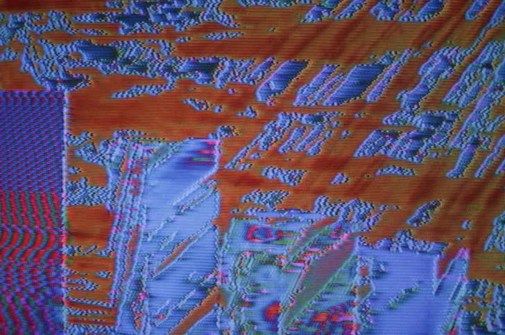 An image displaying 3d rectangles distorts and pixelates as light and color move across it