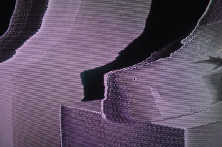 An image on a screen flashes with colorful light and distorts
