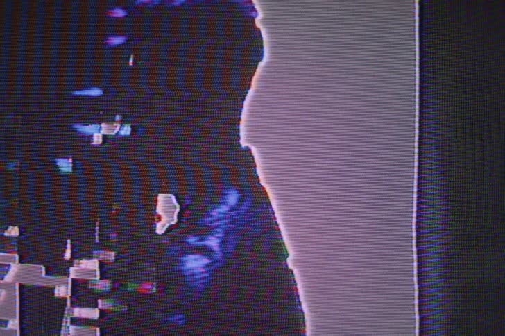A changing digital screen showing the profile of a man in a cap with a beard and zigzag colorful lines
