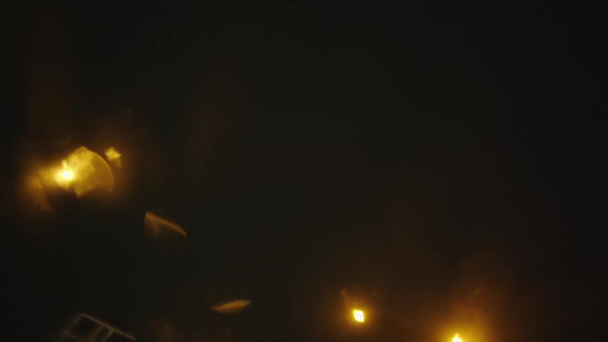Street lights and highway lights glow yellow and blur