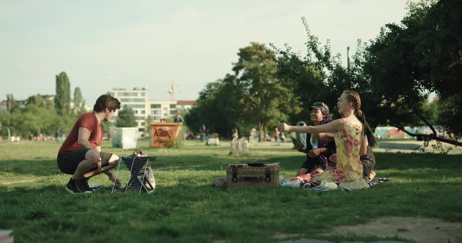 A man throws beers to people at the picnic