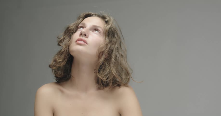 A woman looks up while posing