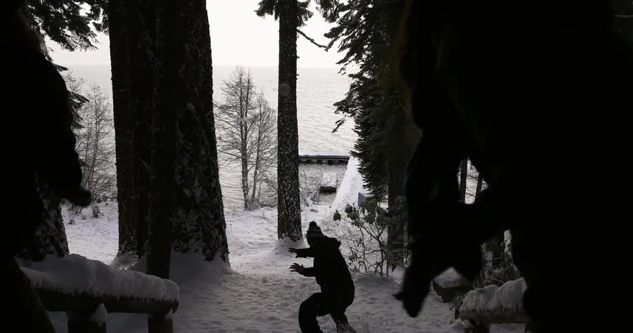 People run down steps throwing snowballs at each other