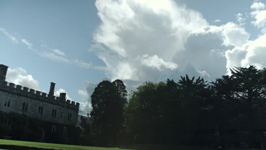 White clouds flowing across the sky over brick building