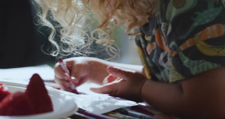 A child is coloring on the floor