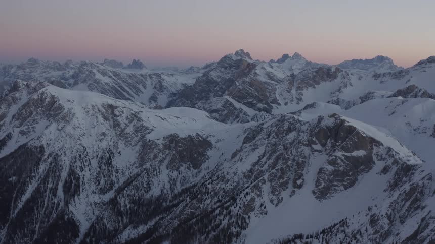 Aerial view of mountains while the sun is setting is displayed