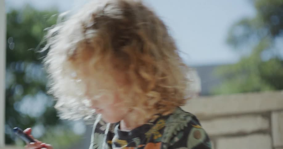 A child is writing with a pencil outside