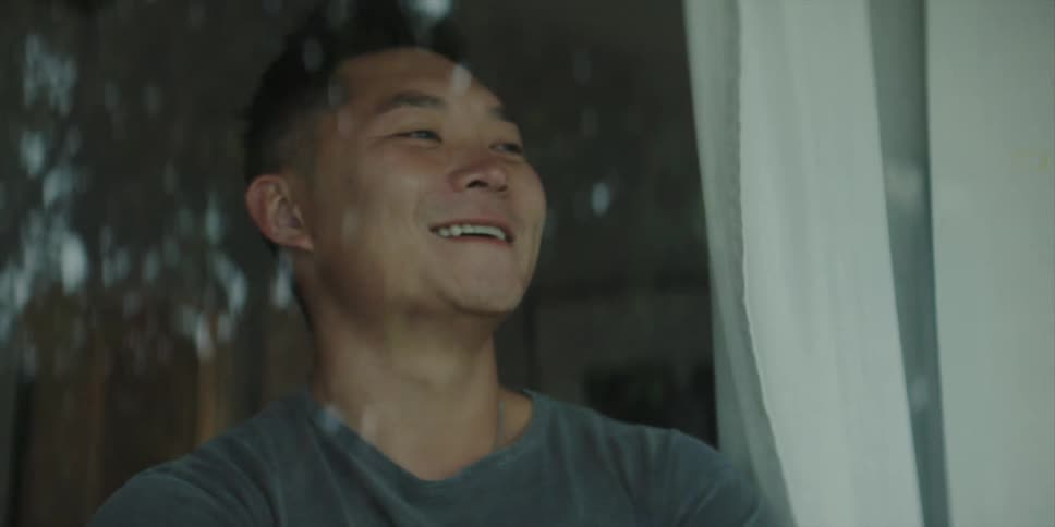 A man is waving to someone from his window